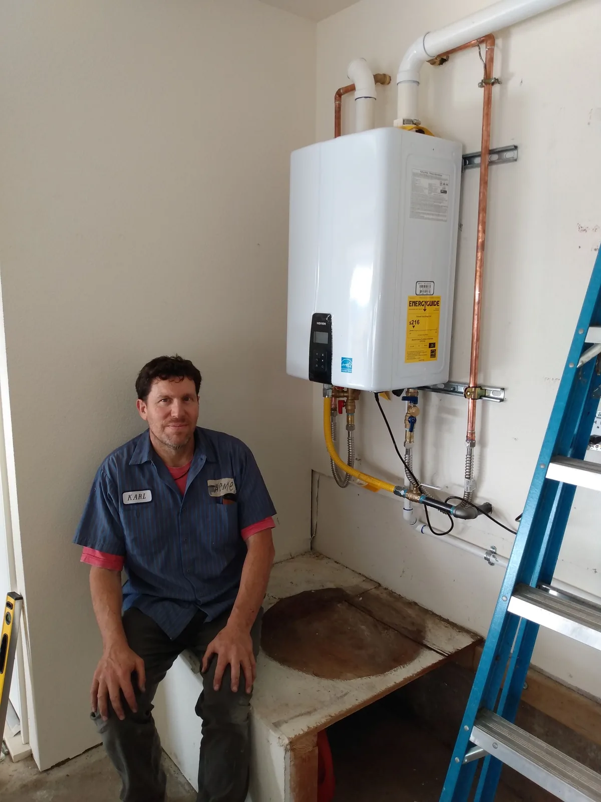 An Avanté Plumbing technician beside a newly installed tankless water heater